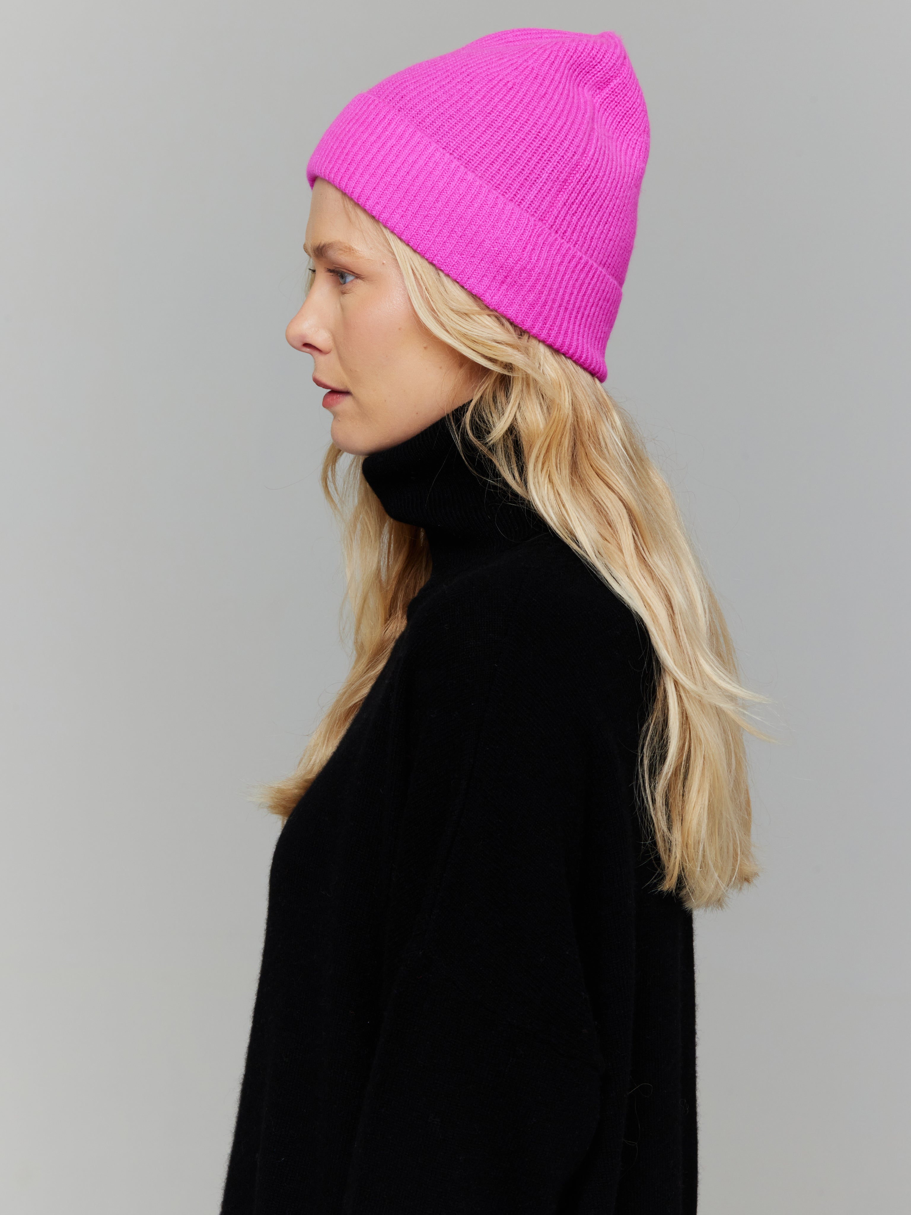 women wearing a pink hat and black roll neck jumper