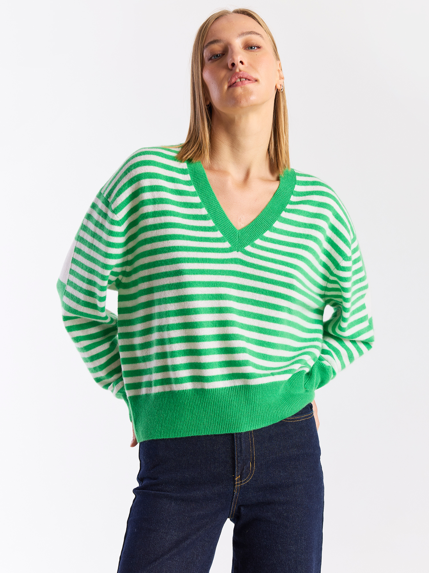 Woman wearing a green and white striped sweater on a white background