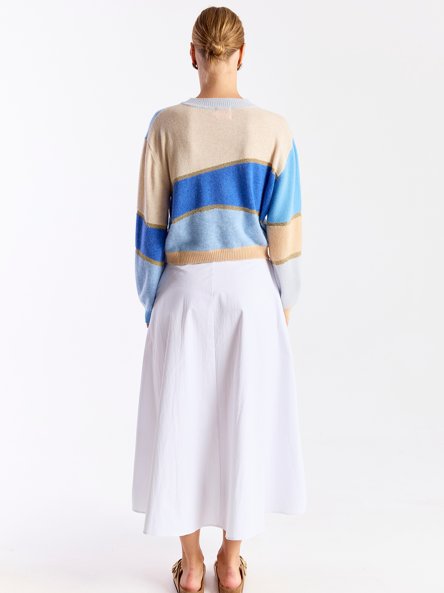 Woman wearing a colorful striped cashmere sweater on a white background