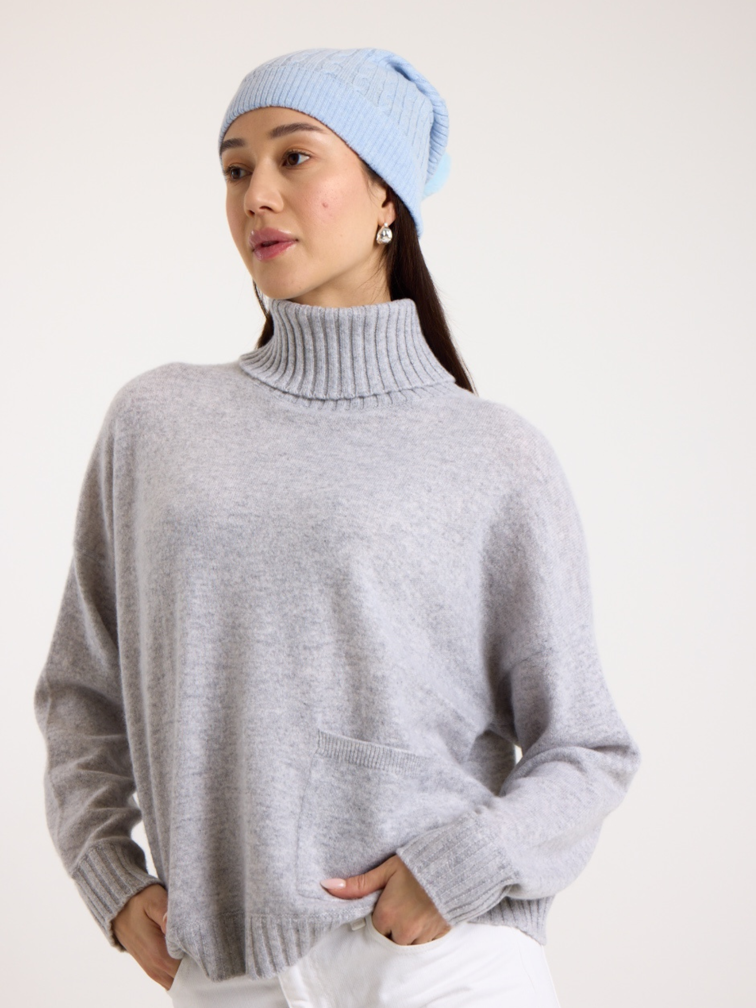 Lady wearing a blue cable cashmere pom hat