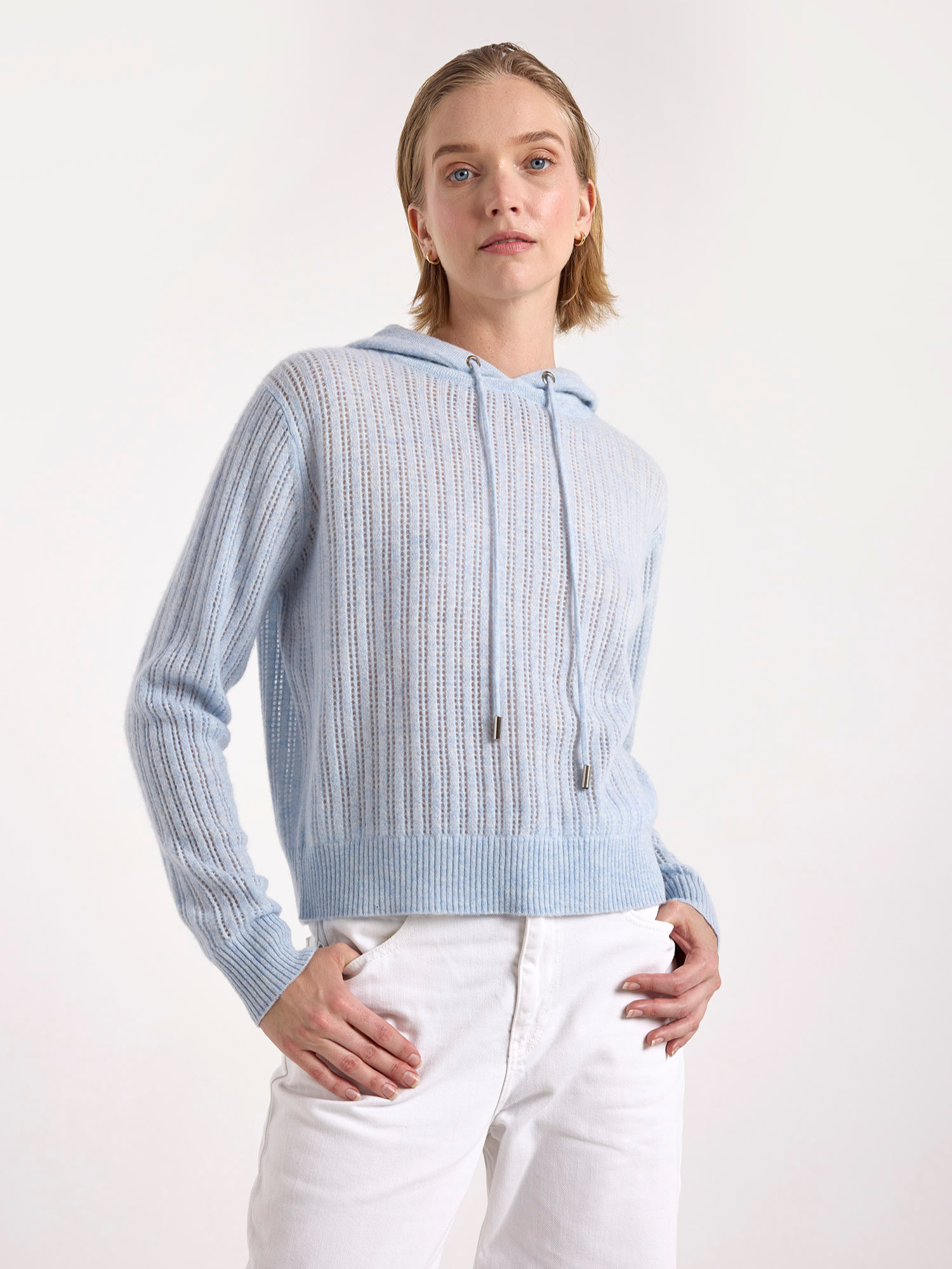 woman wearing a light blue ribbed cashmere hoodie on a white background
