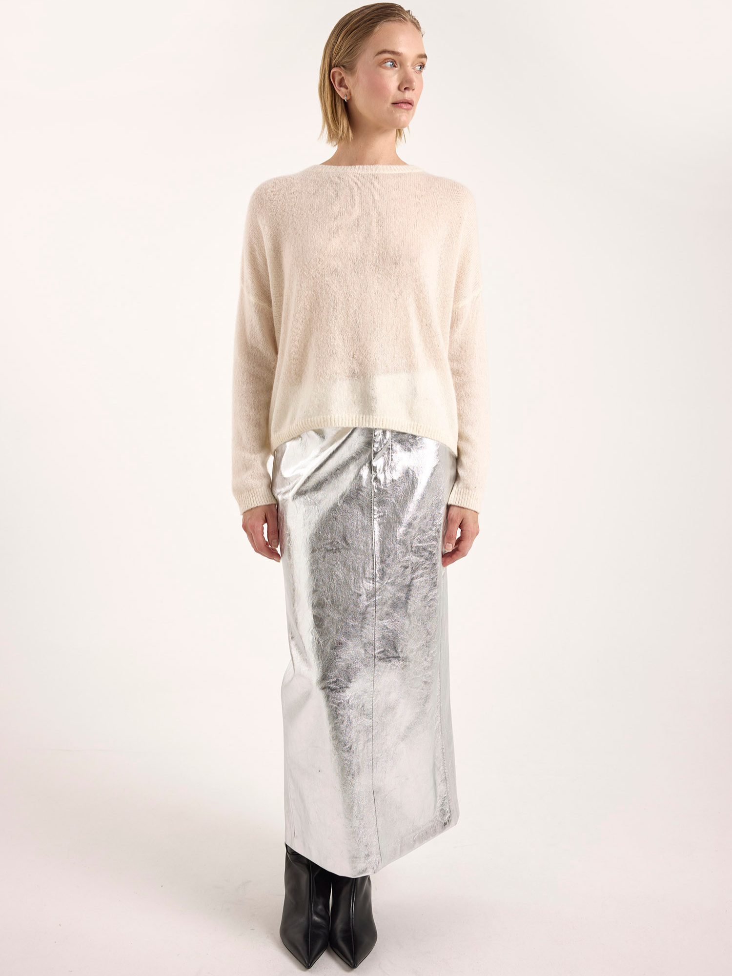 Woman wearing a cream cashmere sweater against a white background