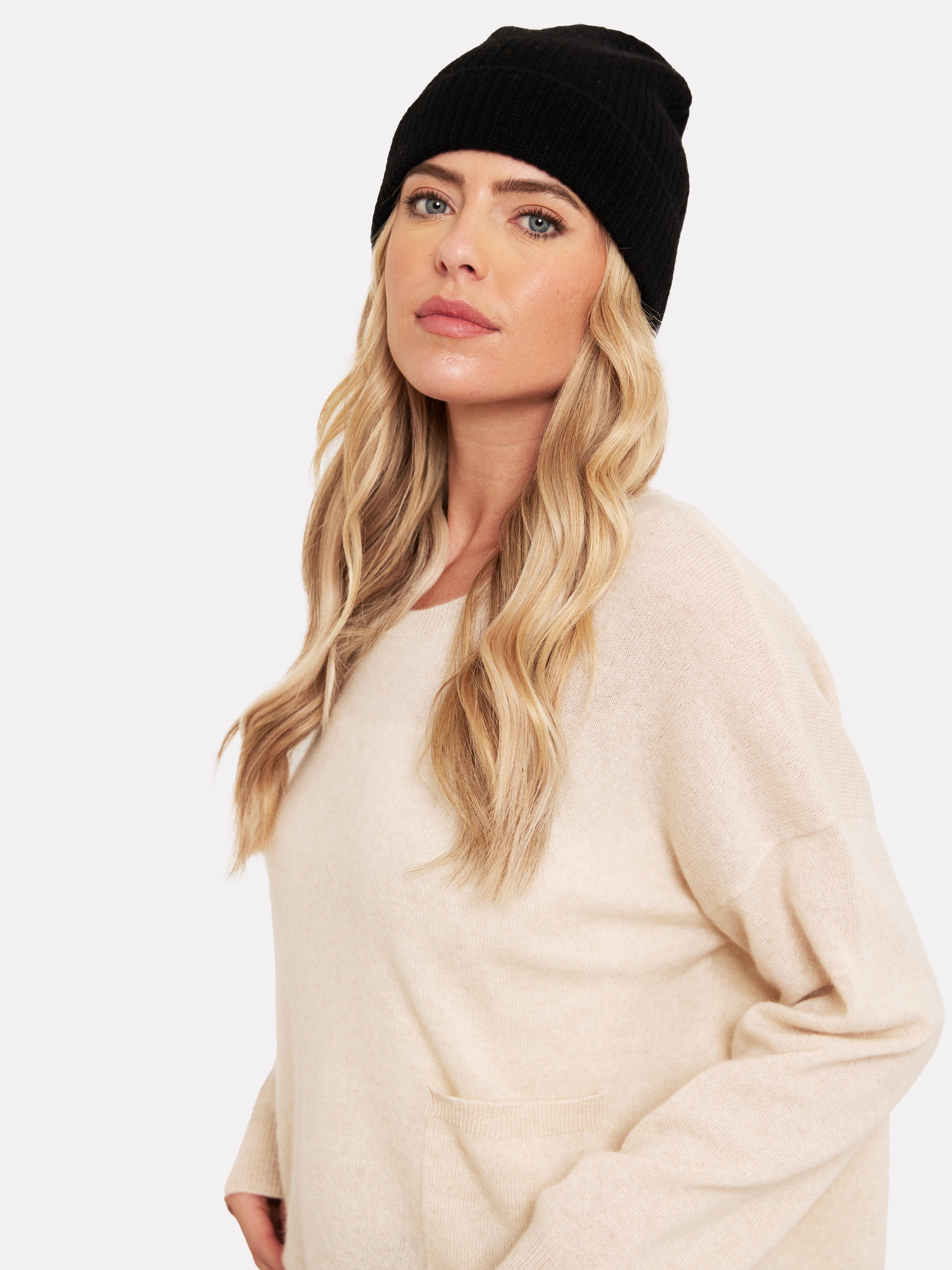 Woman wearing a black hat and beige jumper