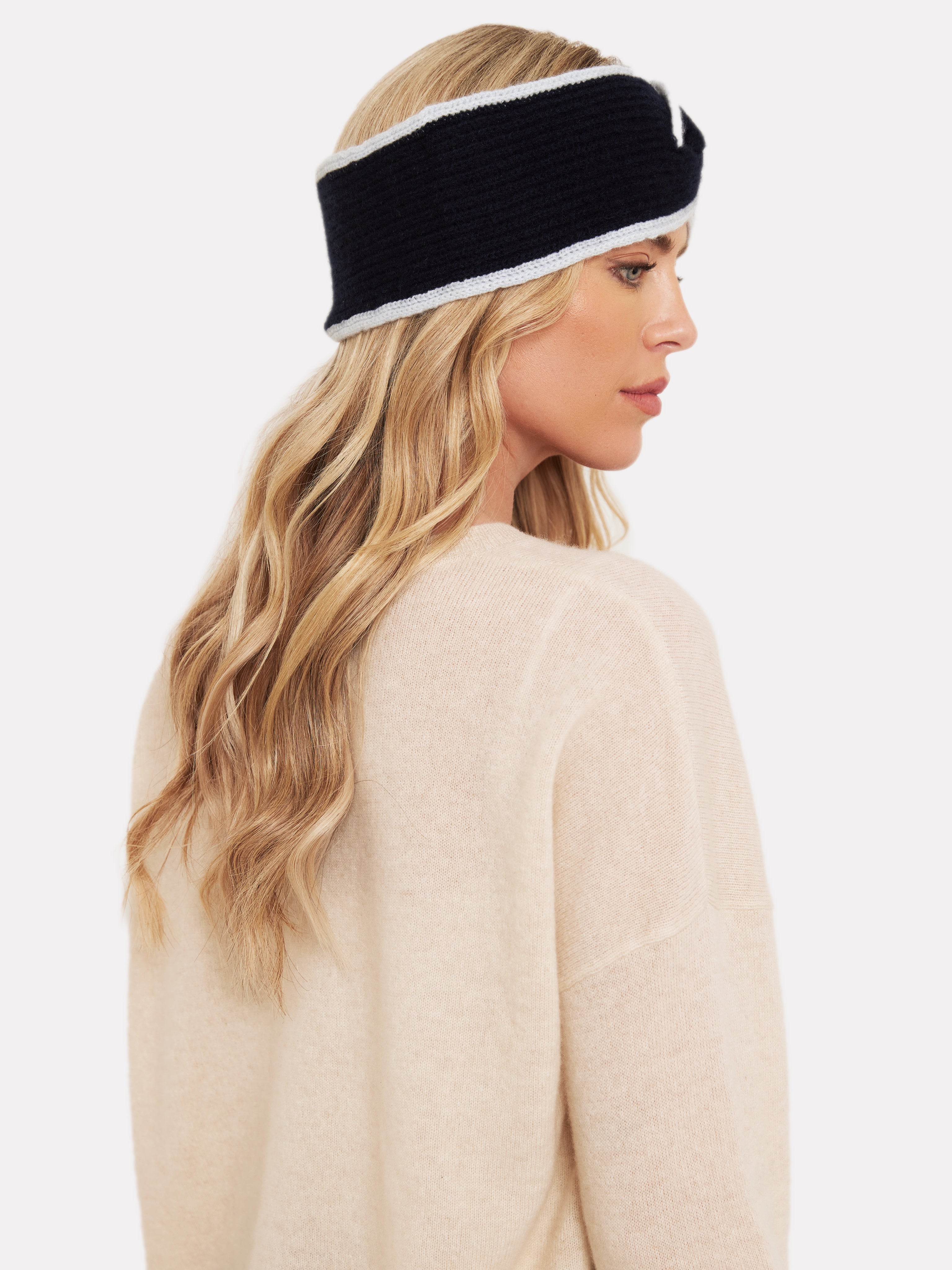 women wearing a navy blue headband with light blue tipping and beige jumper
