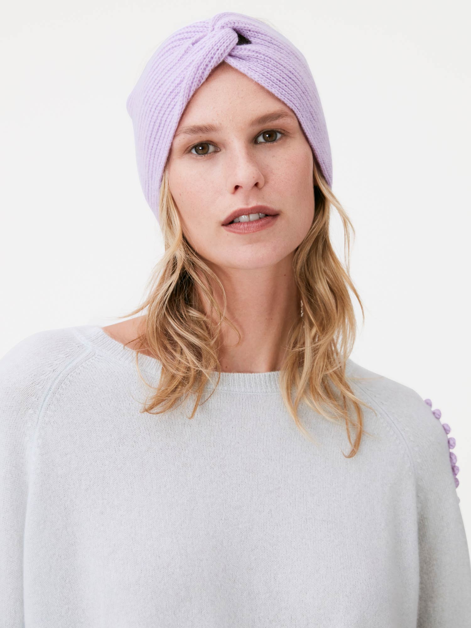 Woman wearing a light purple headband against a white background