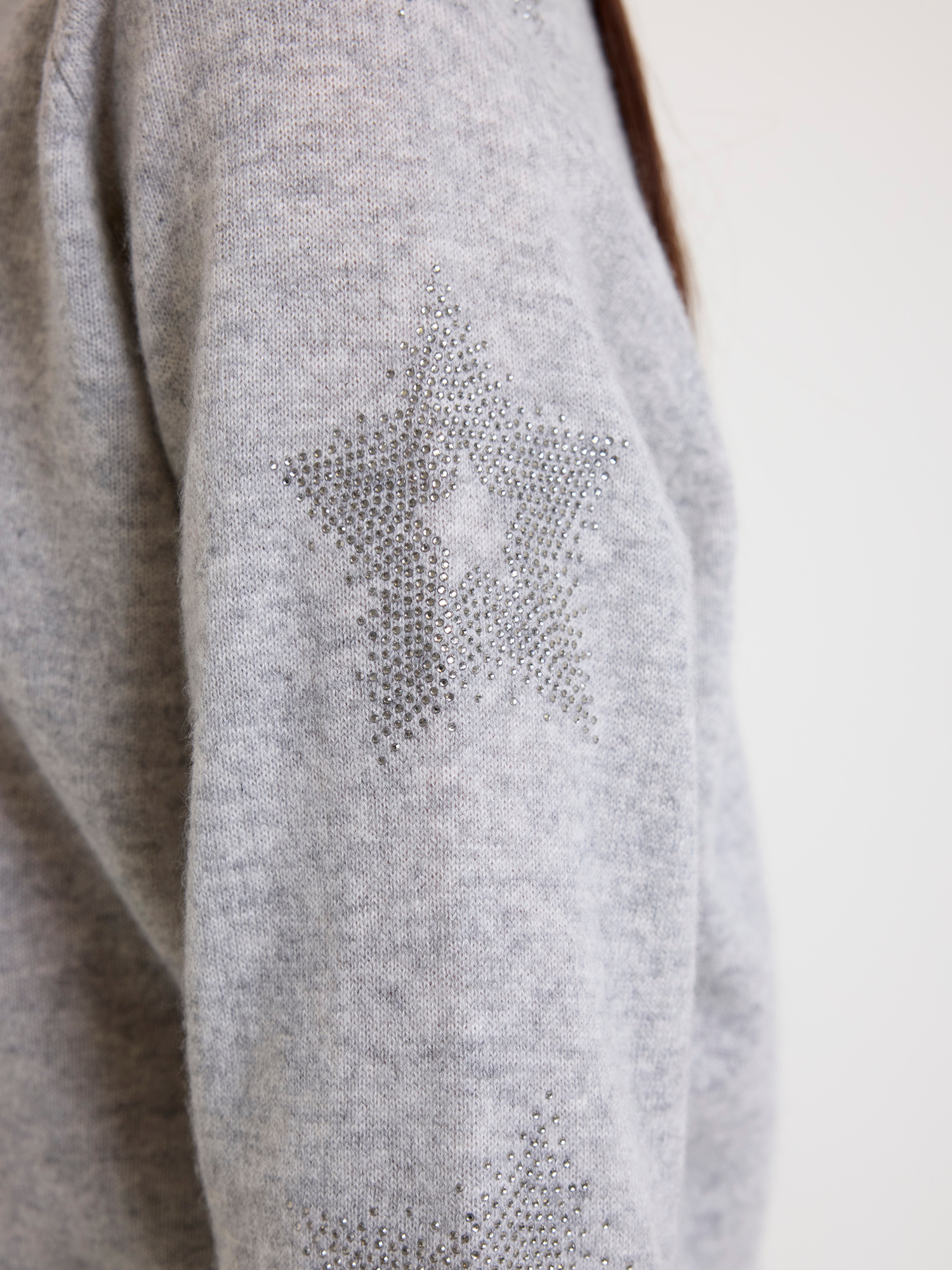 Close-up of a grey jumper with star rhinestone detail
