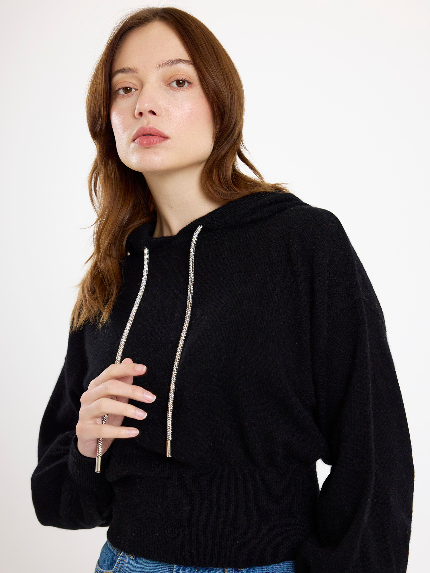 Woman wearing a black hoodie on a white background