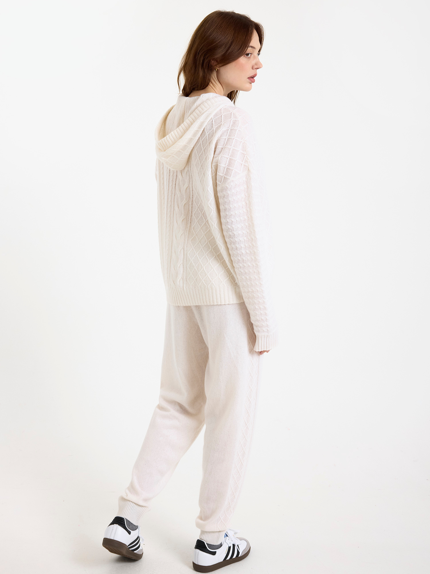 Women wearing a white cable knit jogger set with a matching hoodie and joggers on a white background
