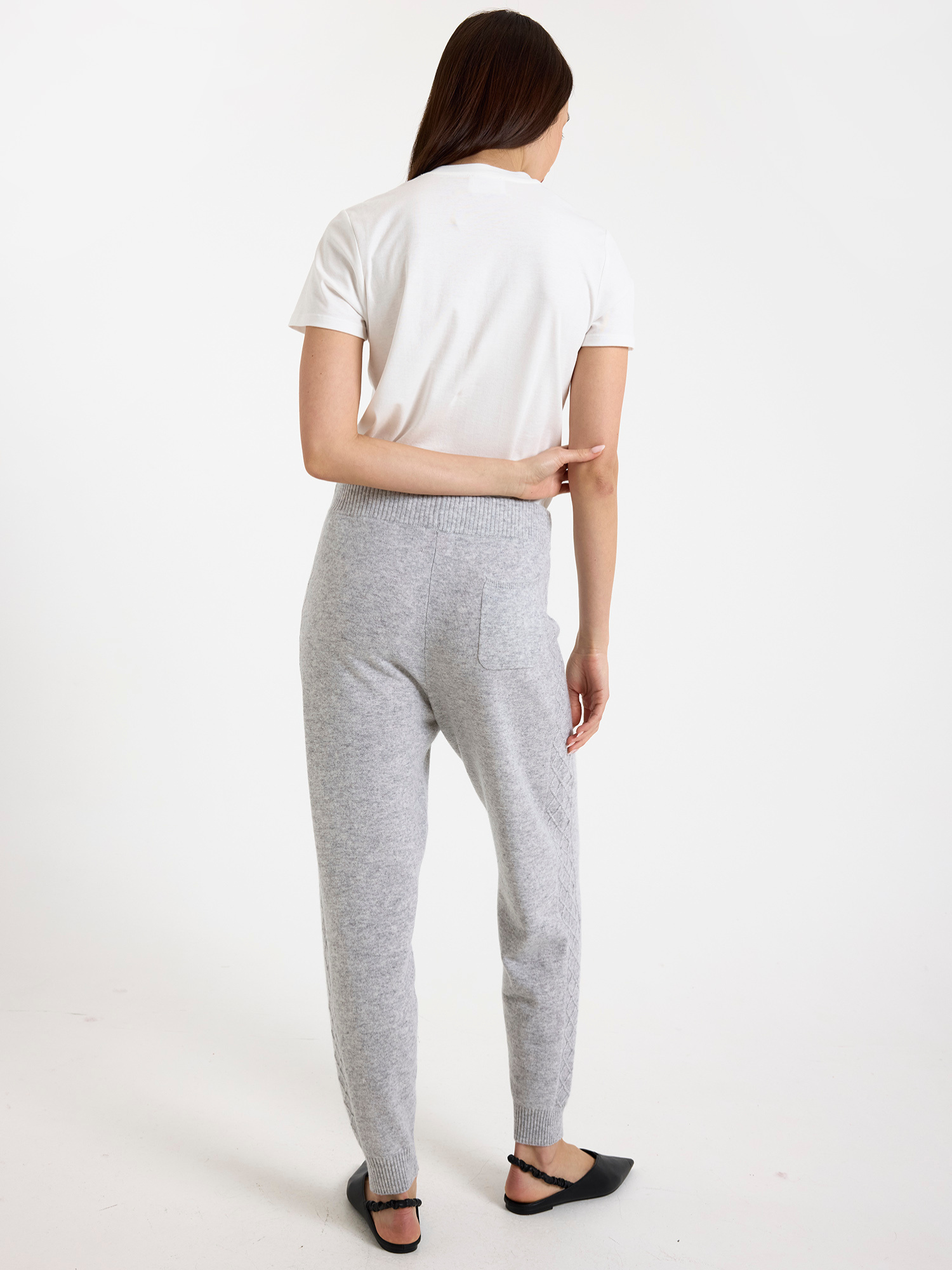 Women wearing a white t-shirt and grey joggers on a white background