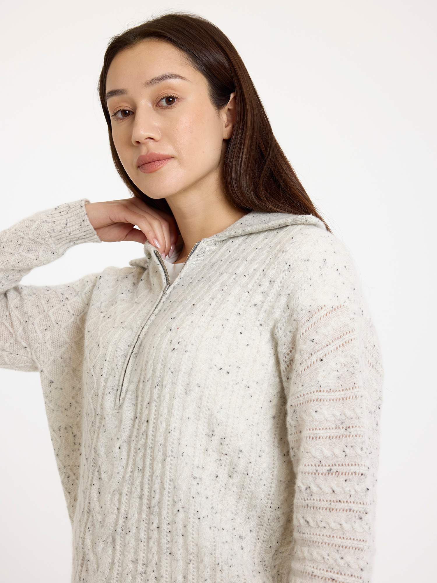 Woman wearing a grey speckled half zip-up sweater on a white background