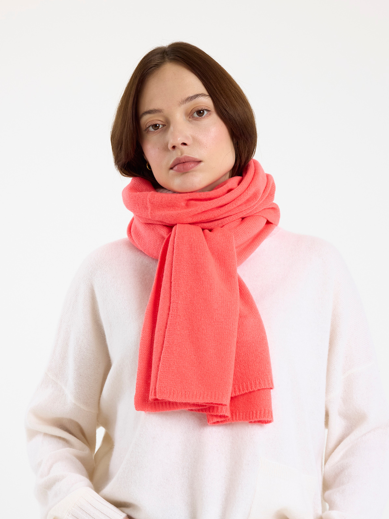 Woman wearing a bright pink scarf against a white background