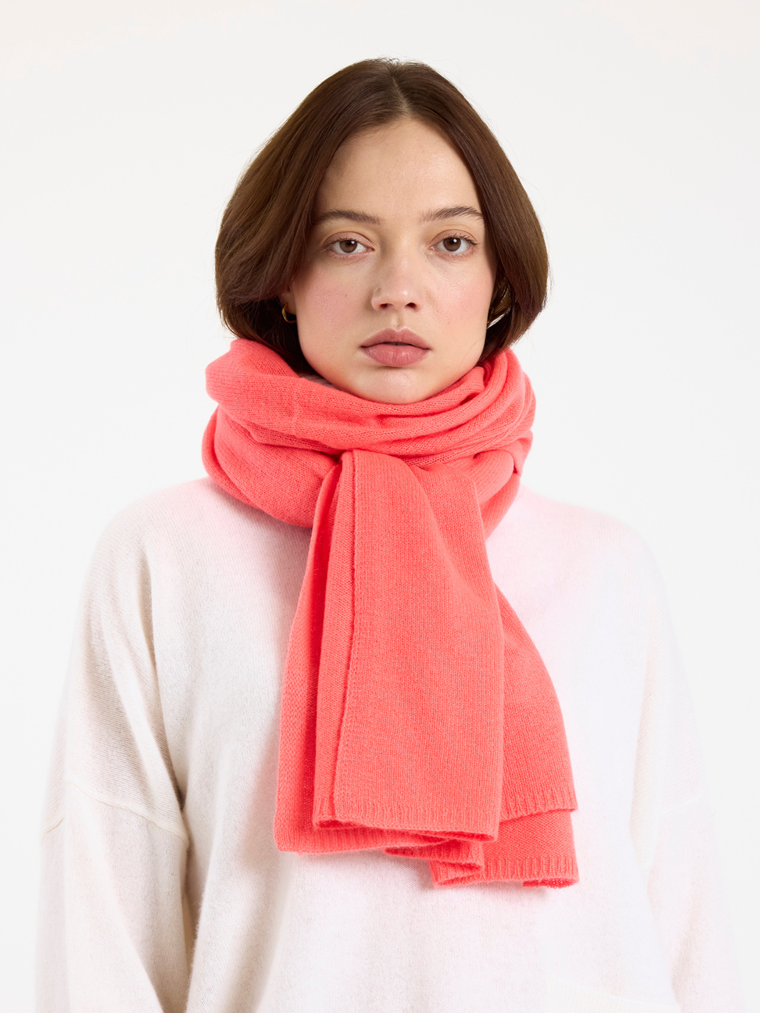 Woman wearing a bright pink scarf on a white background
