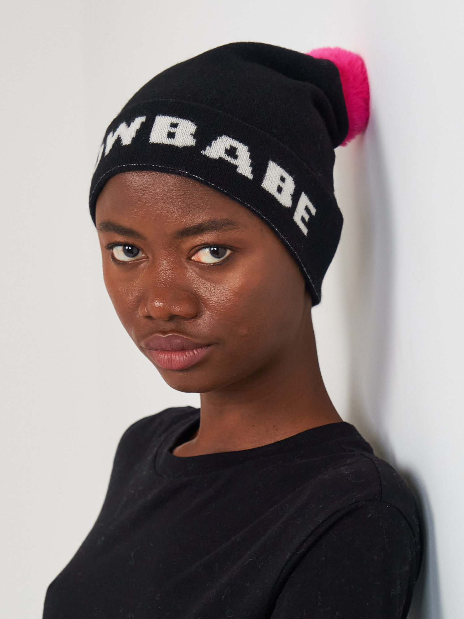 Person wearing a black beanie with 'Snow Babe' text against a white background