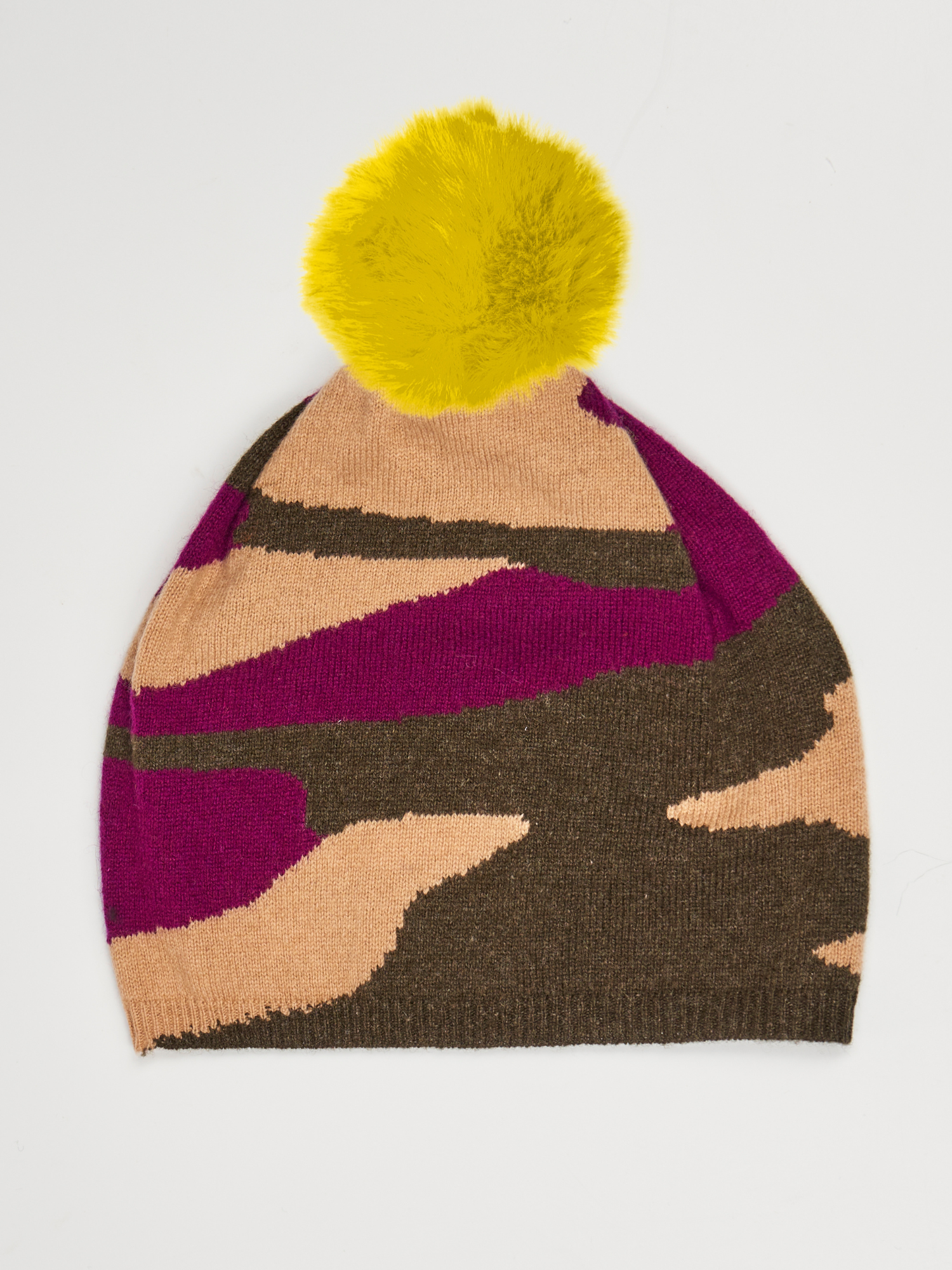 Flat lay of a camo pattern hat in green, beige and purple with a yellow pom pom