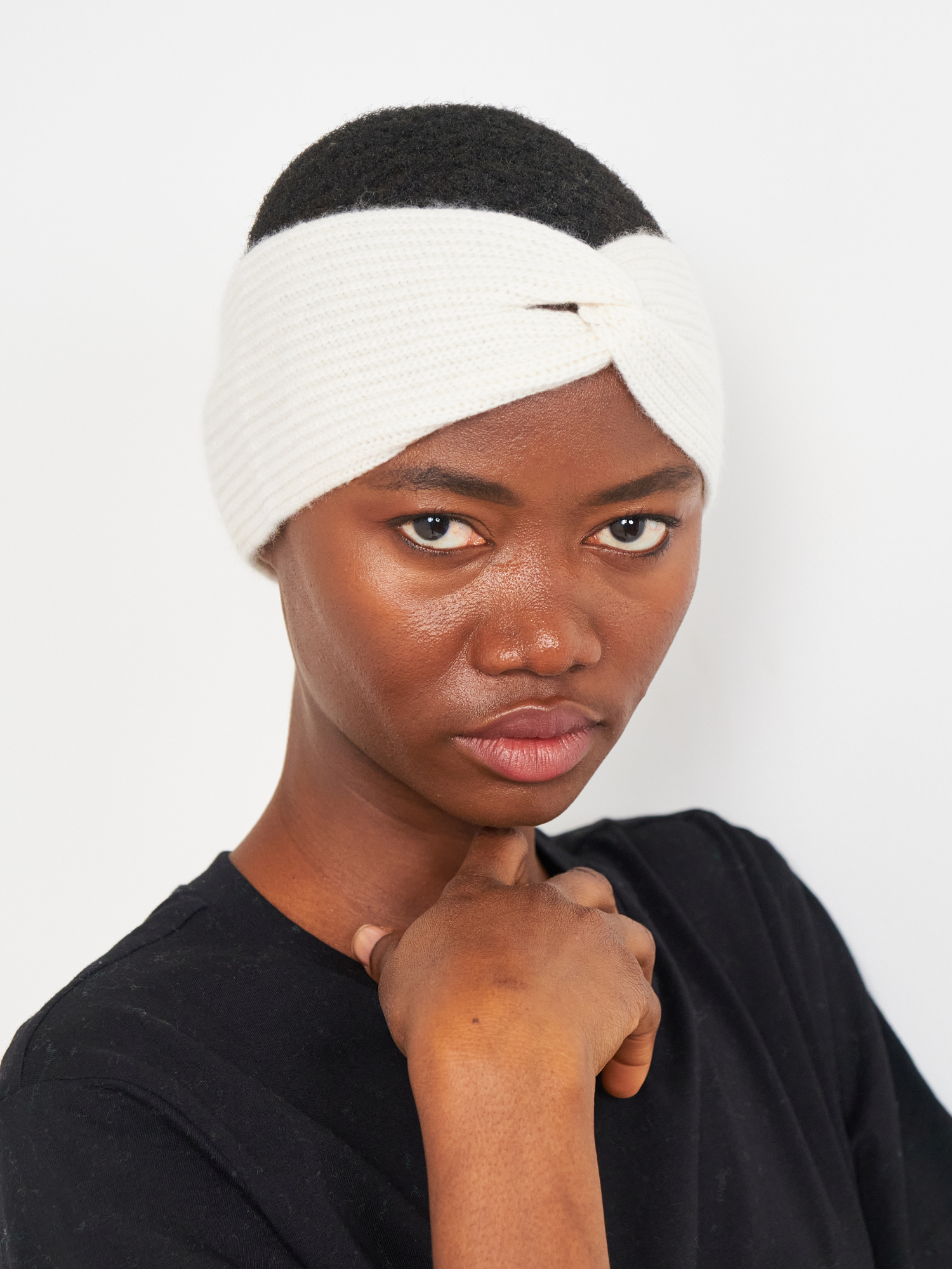 Person wearing a white headband against a plain background