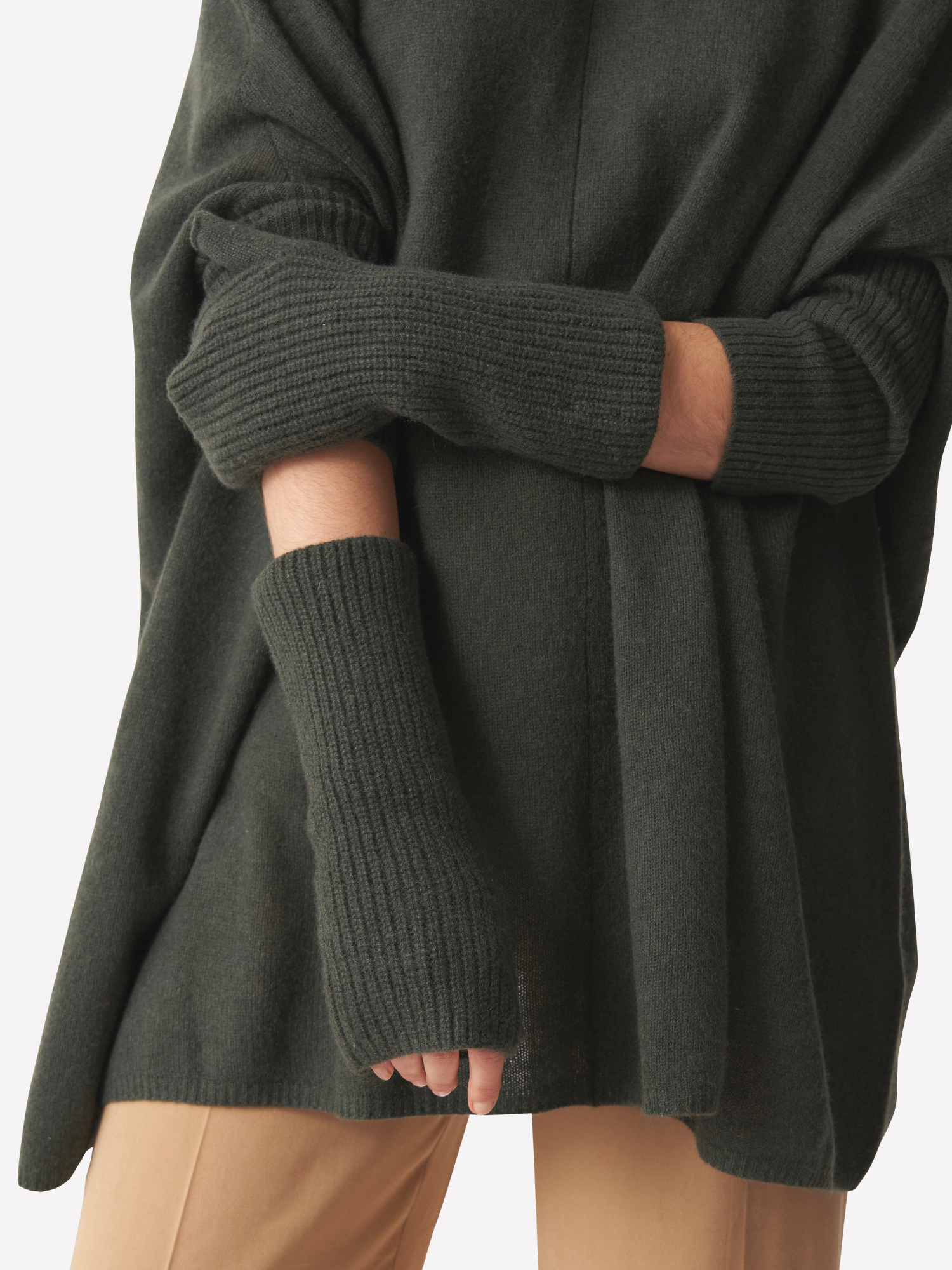 Dark green sweater and matching wrist warmers worn by a person on a white background