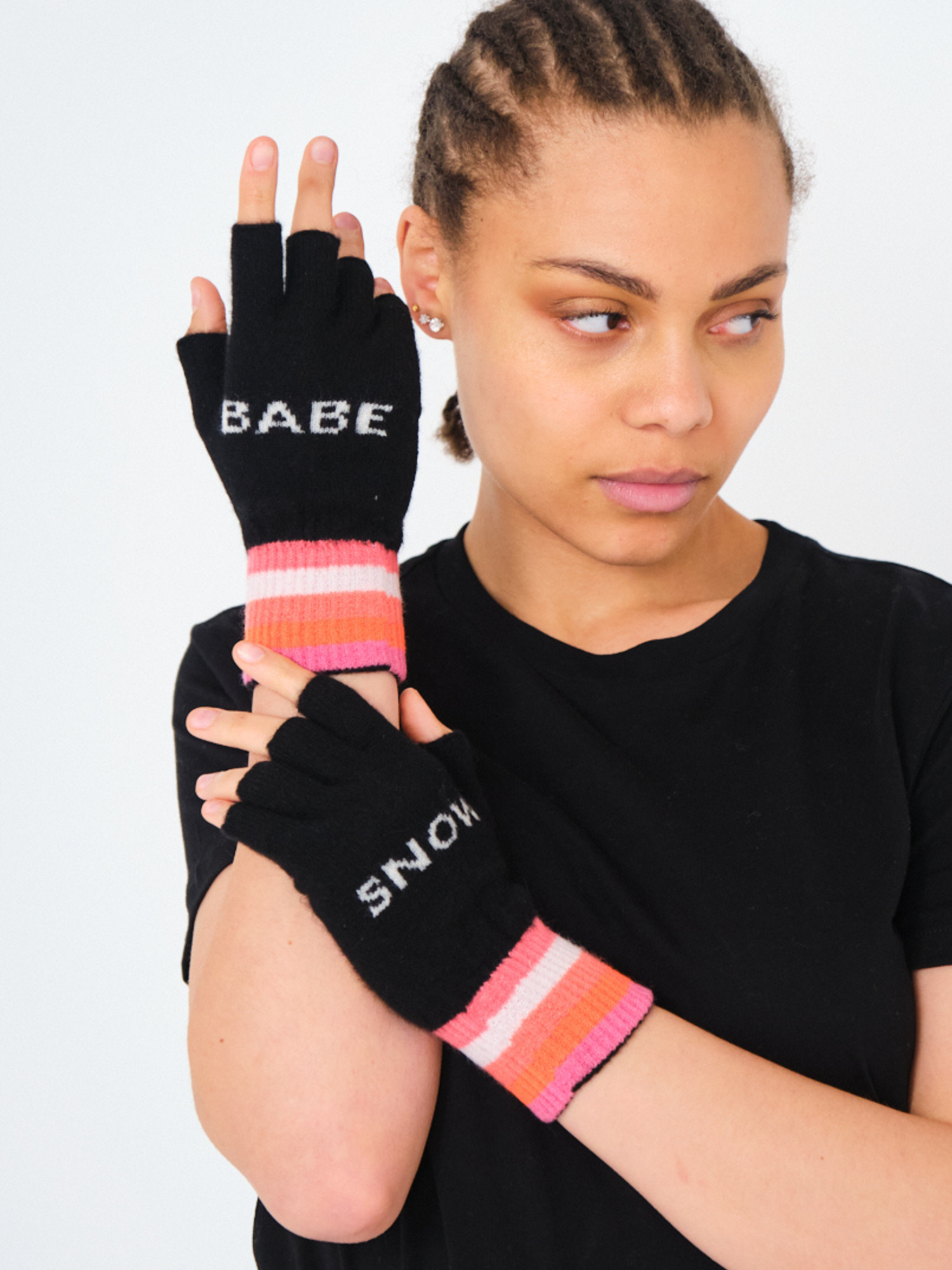 Person wearing black fingerless gloves with colorful stripes and text on a white background