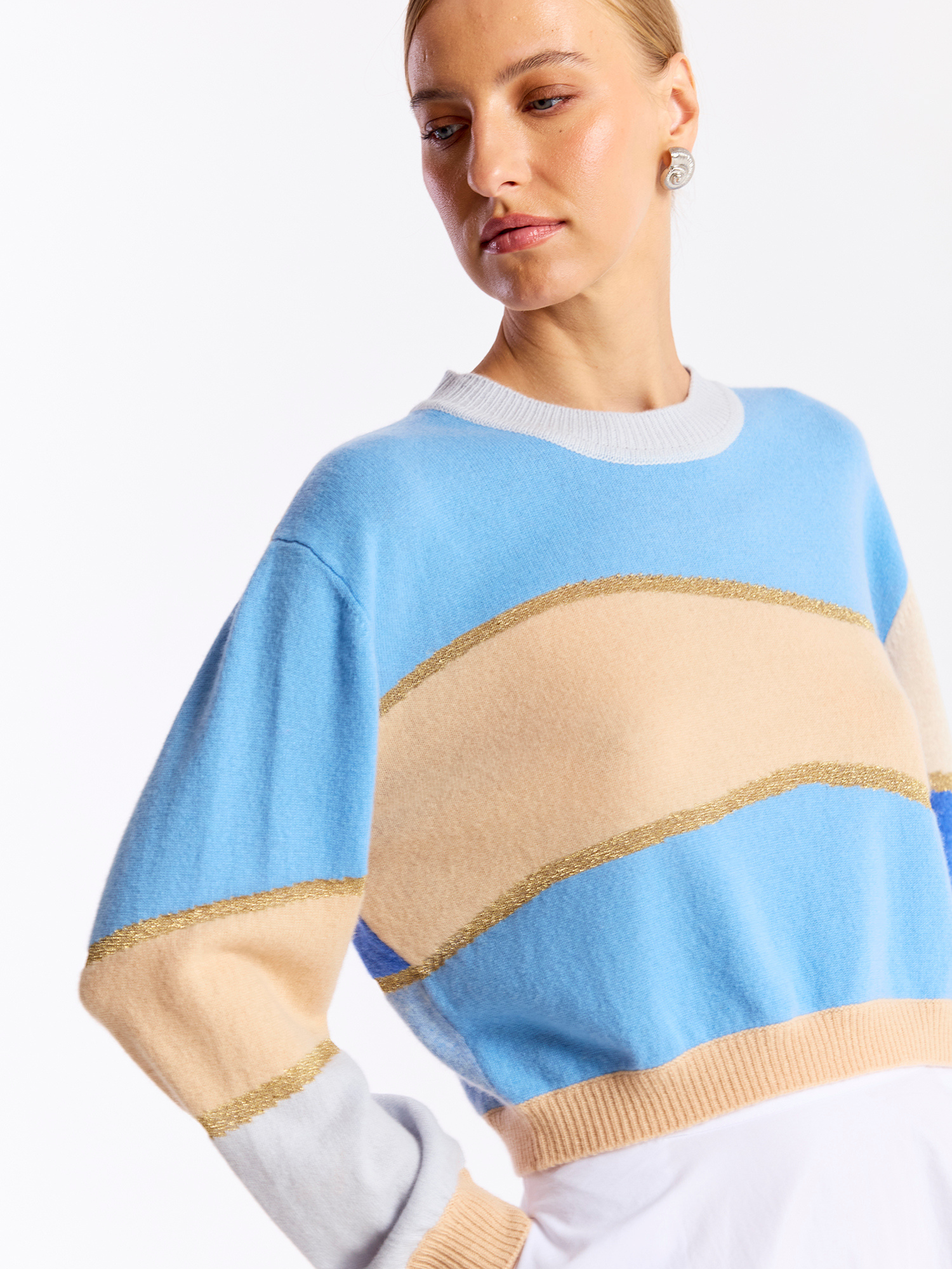 Woman wearing a colorful striped cashmere sweater on a white background