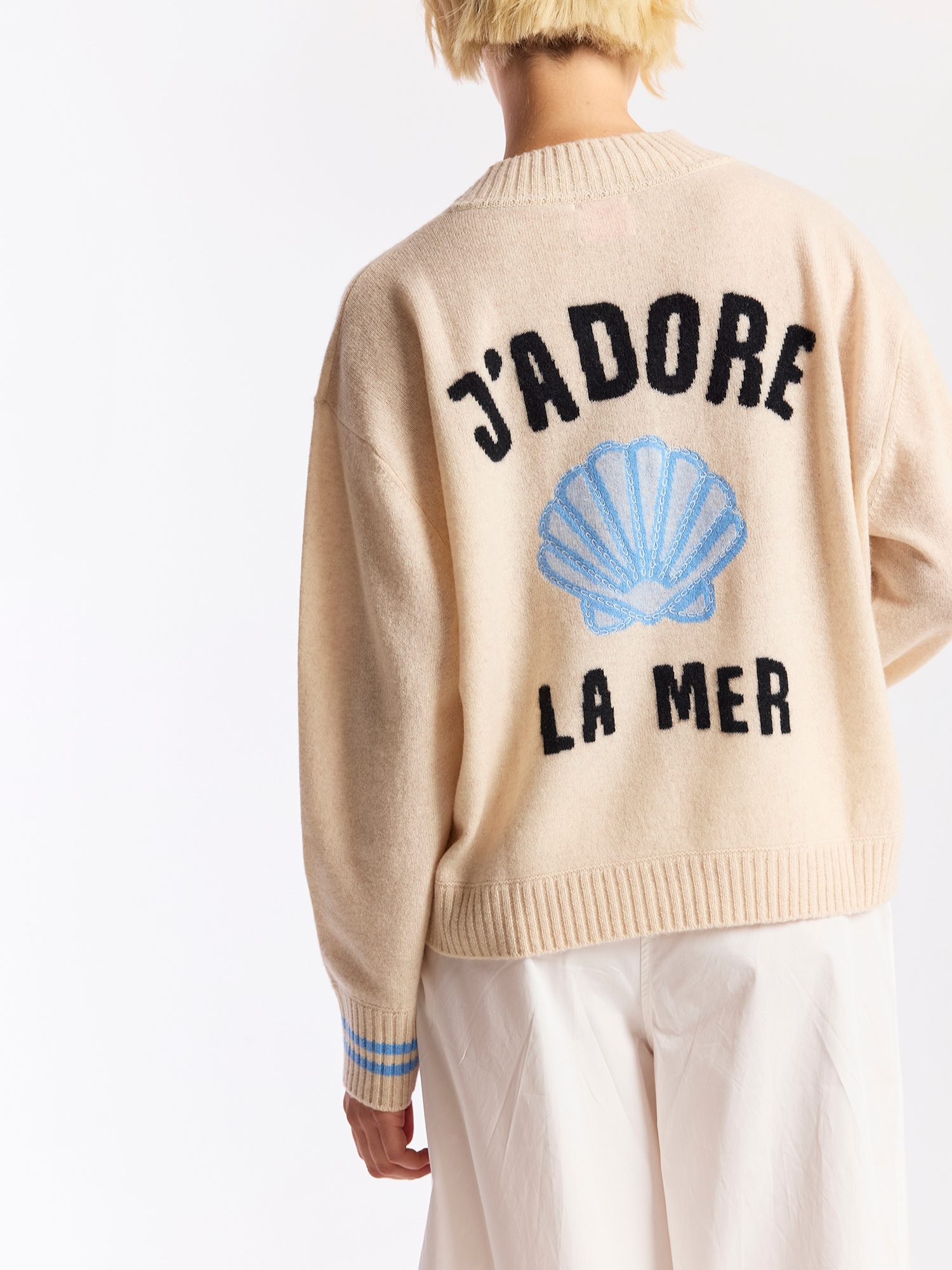 Beige sweater with 'J'adore la Mer' text and blue shell design on a white background