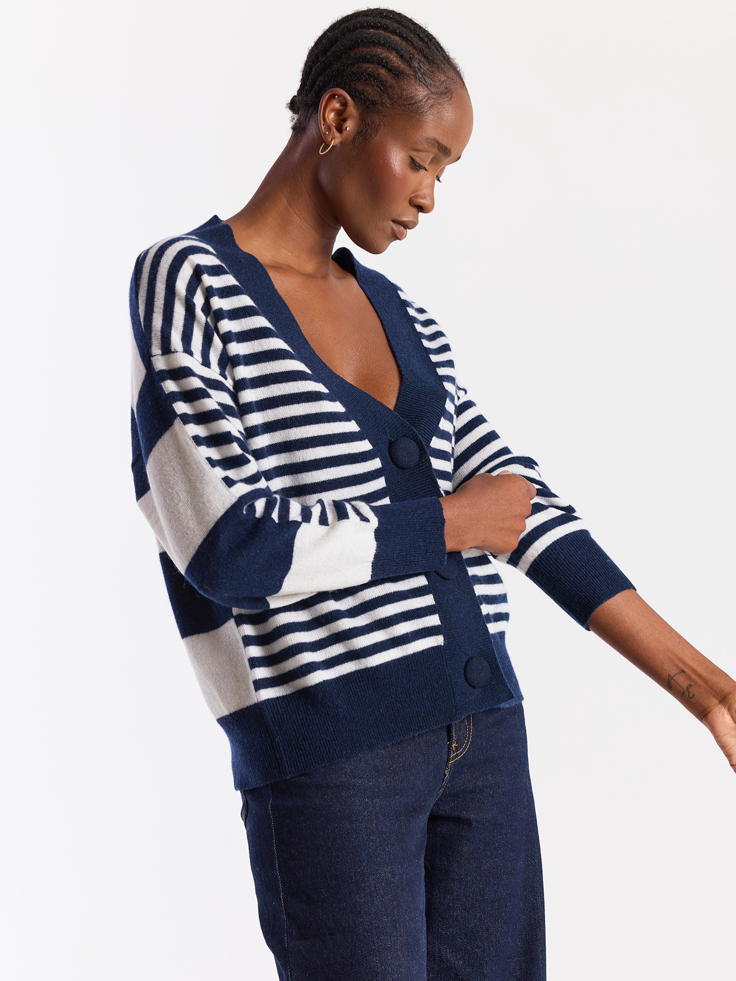 Woman wearing a navy and white striped cardigan on a plain background