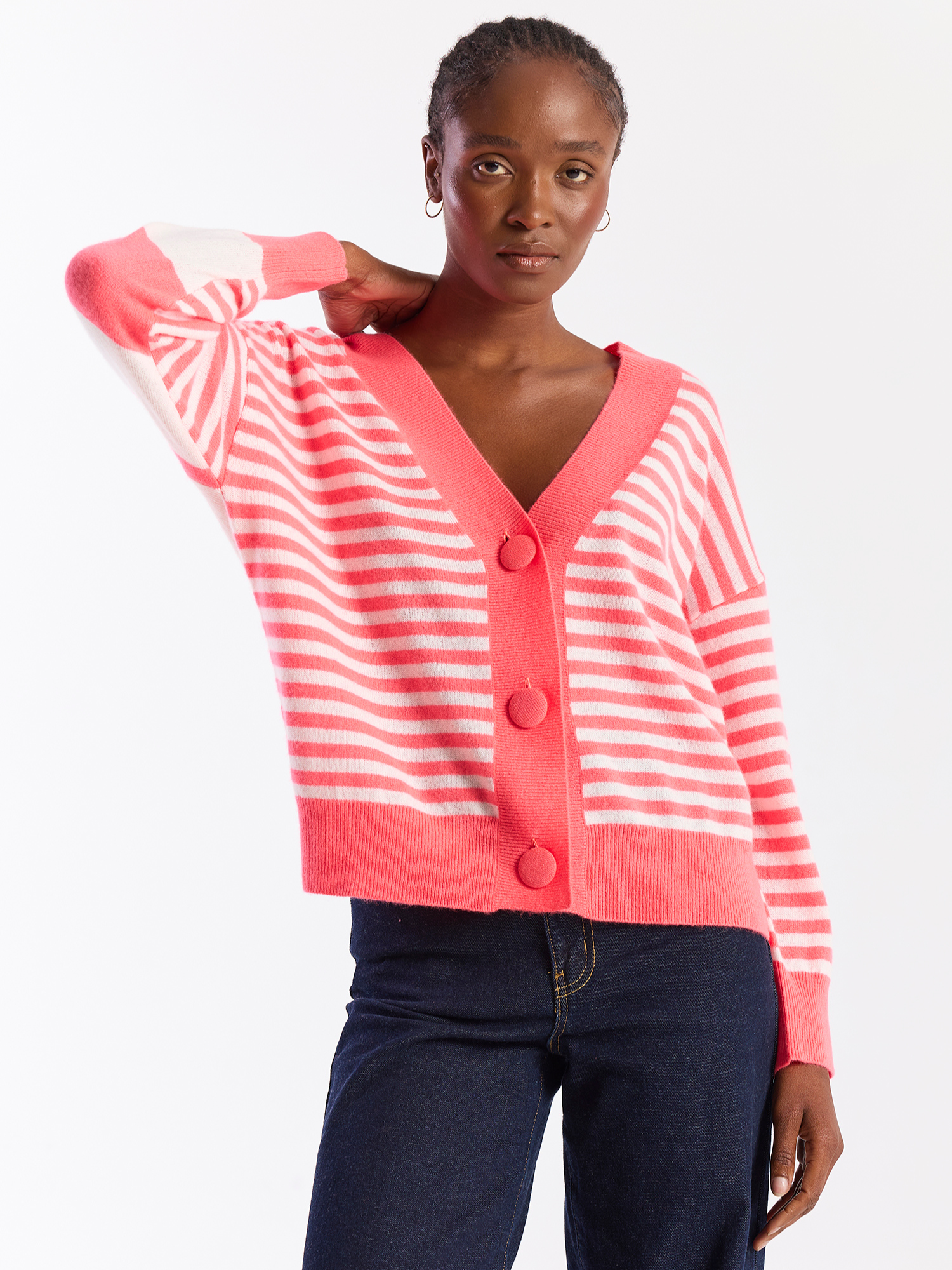 Woman wearing a pink and white striped cardigan on a white background