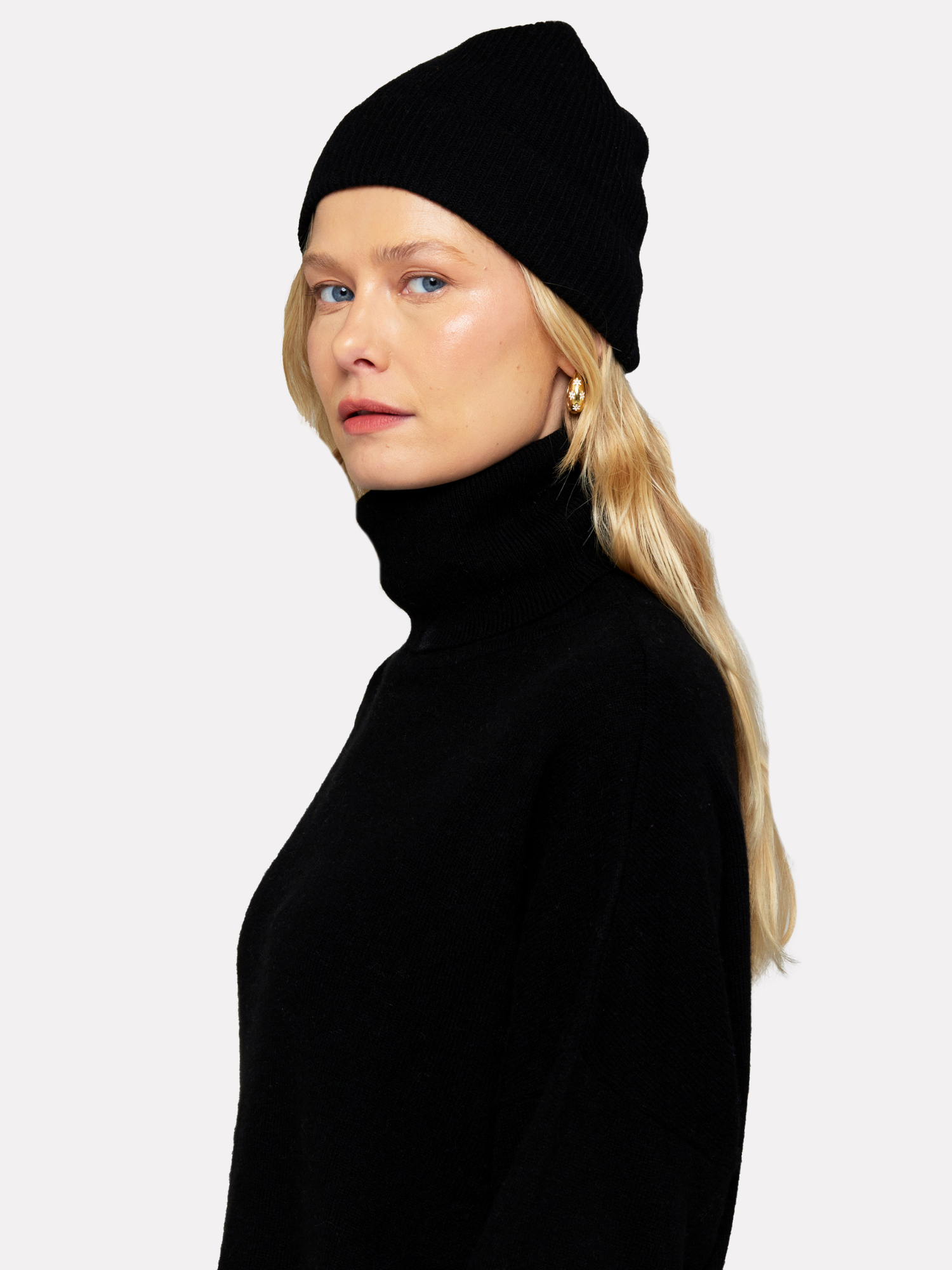 Person wearing a black turtleneck and beanie on a white background