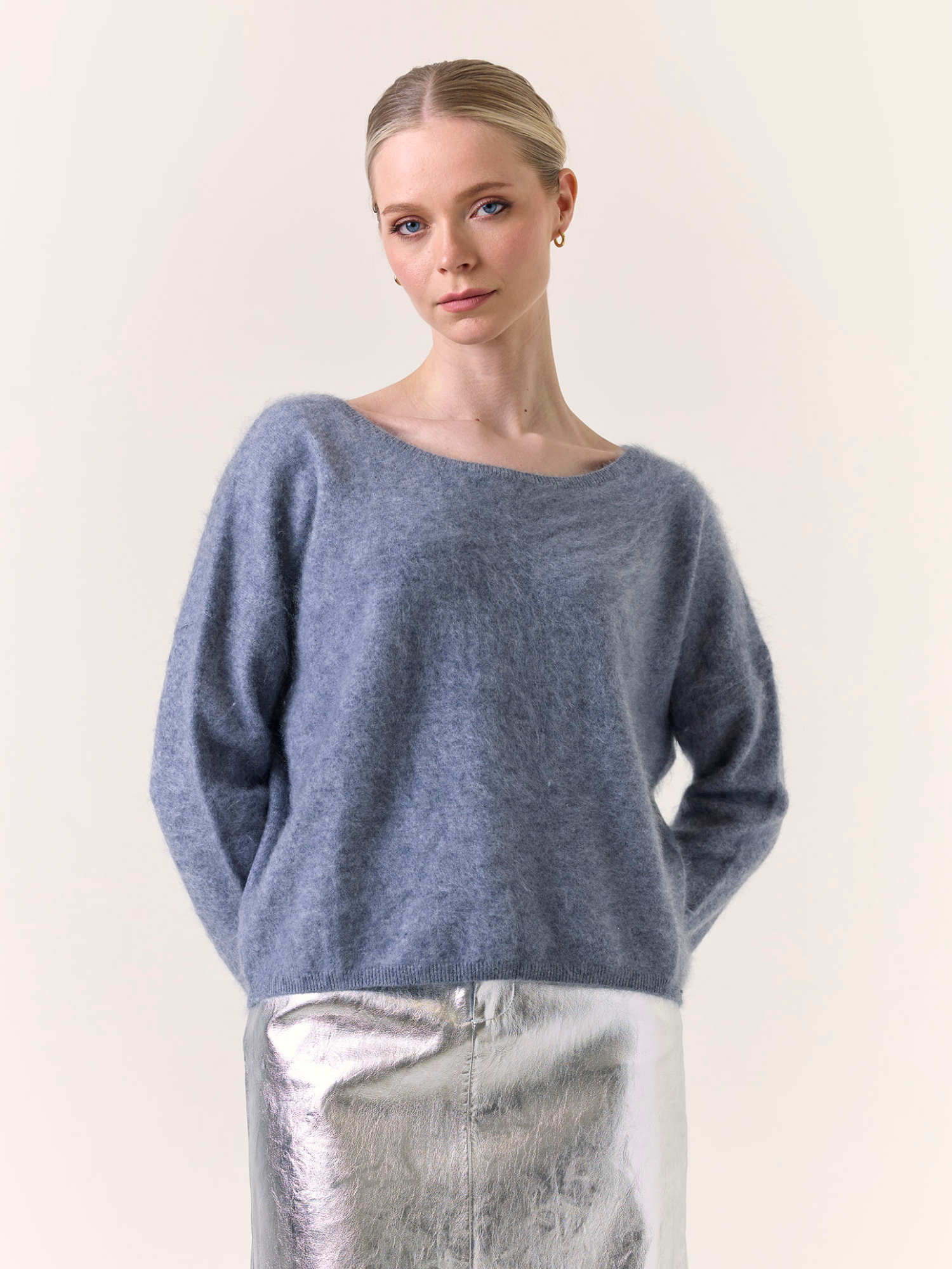Woman wearing a blue sweater against a plain background