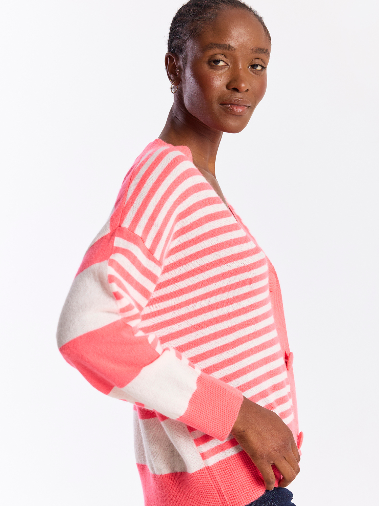 Woman wearing a pink and white striped sweater on a white background
