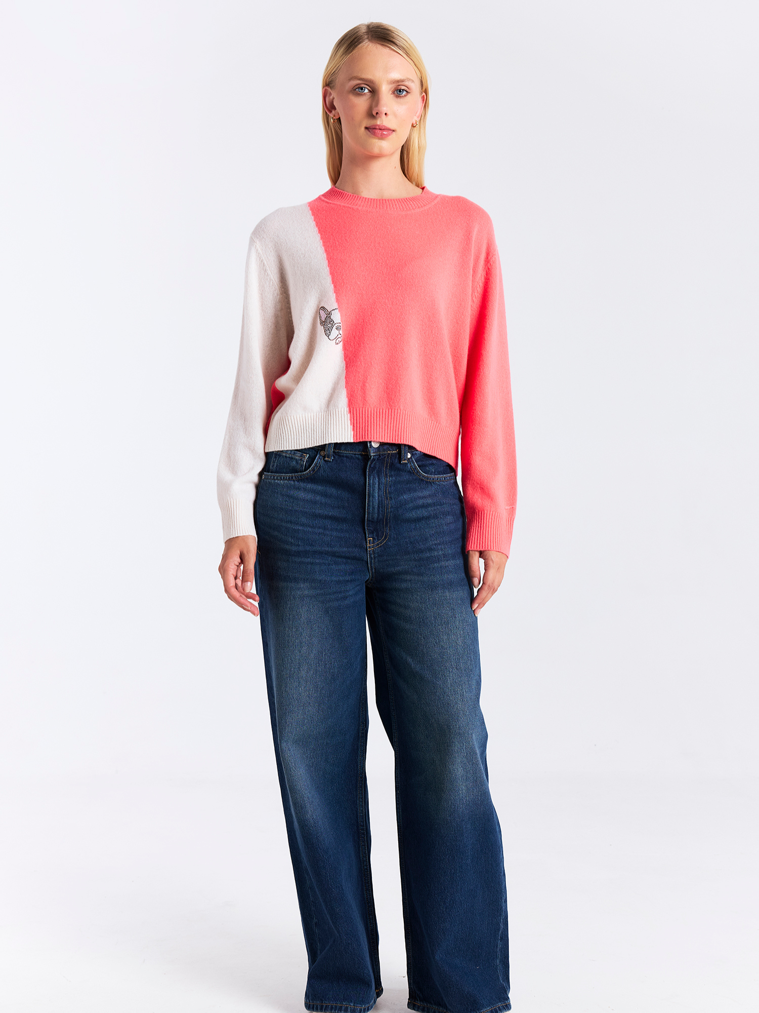 Woman wearing a two-tone sweater and jeans on a white background
