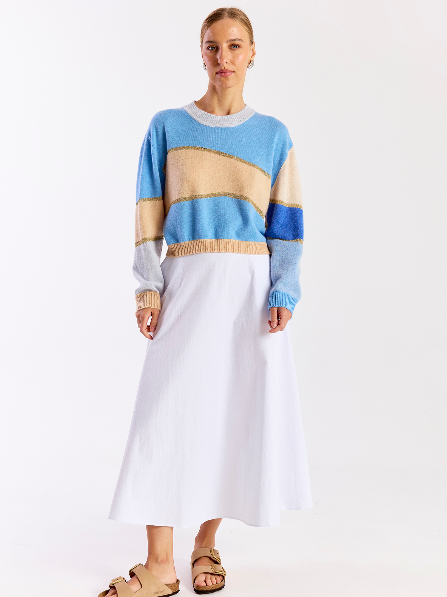 Woman wearing a colorful striped cashmere sweater on a white background