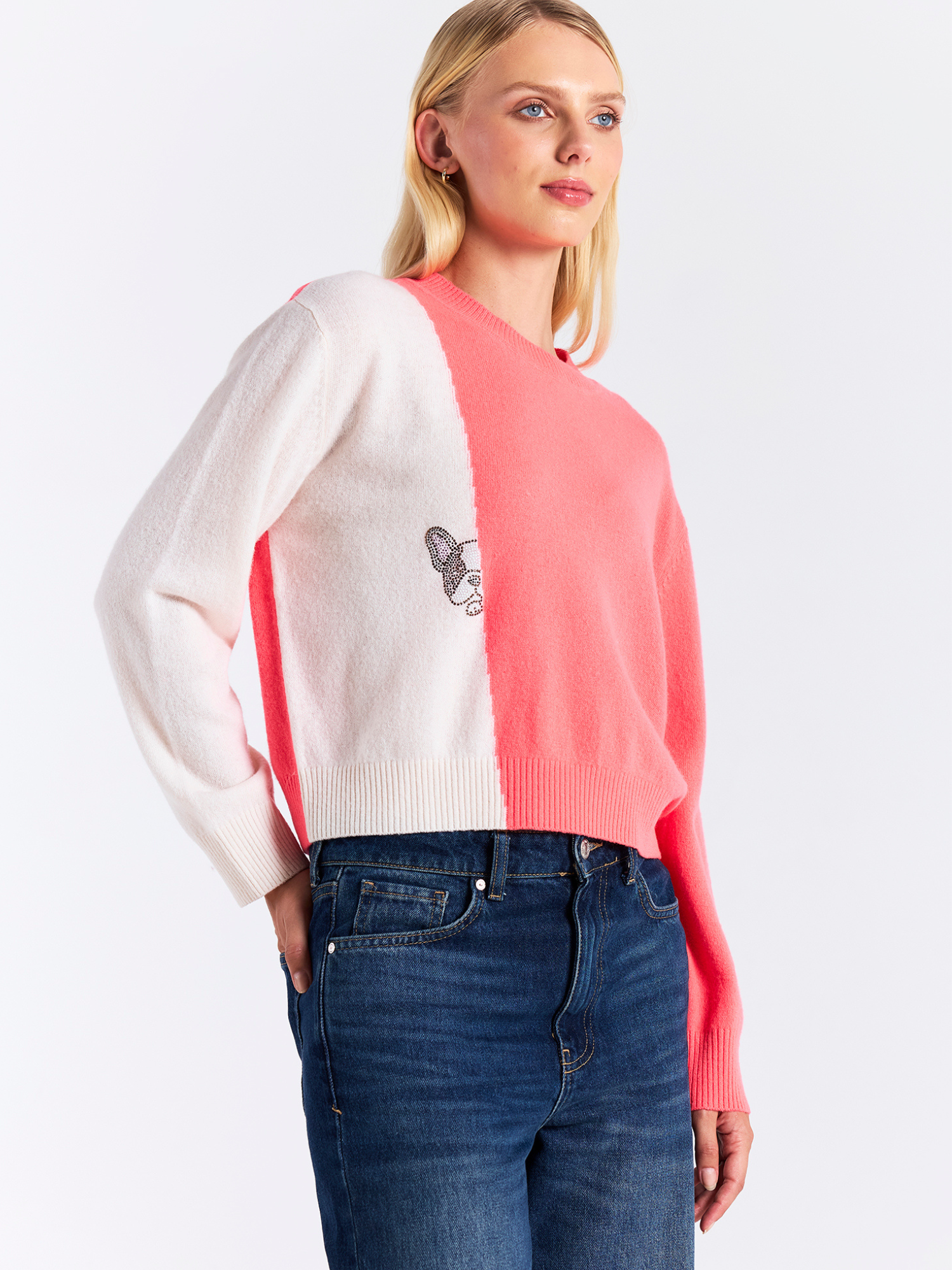 Woman wearing a two-tone sweater with white and pink colors on a plain background