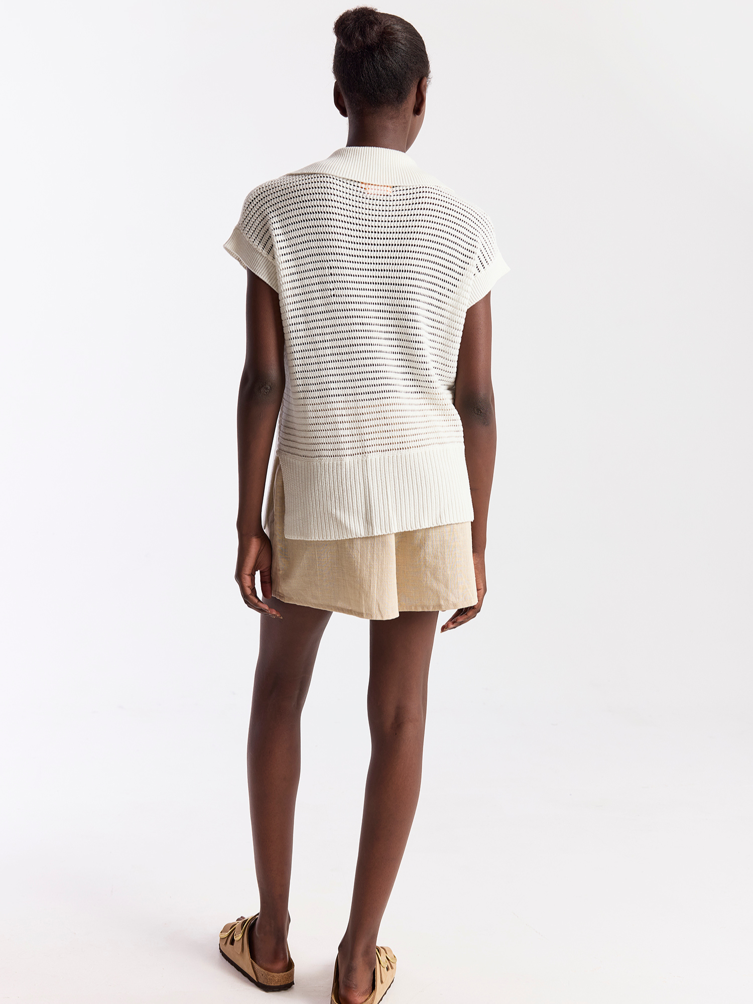 Person wearing a white striped shirt and beige skirt on a white background