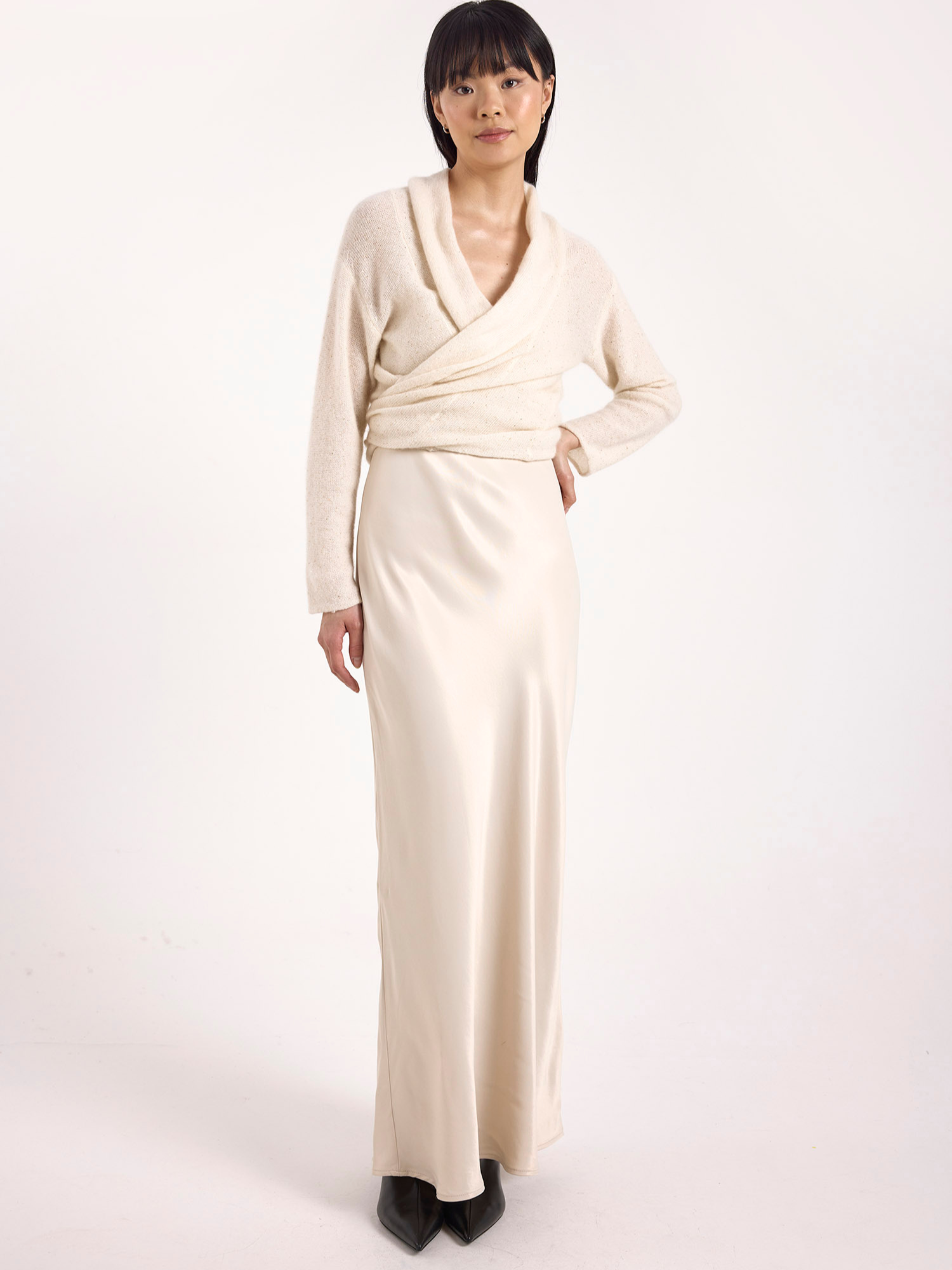 Woman wearing a long beige dress on a white background
