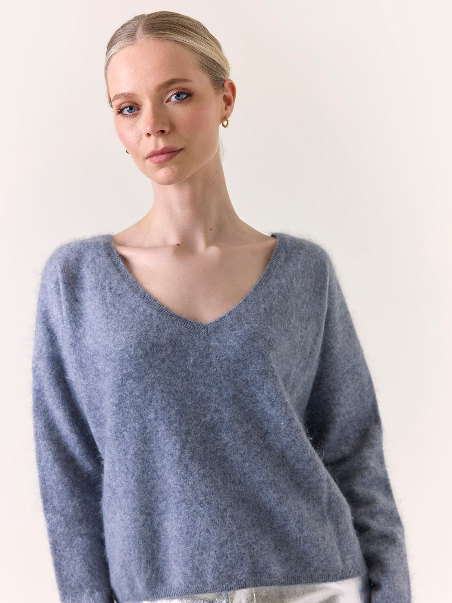 Woman wearing a blue sweater against a plain background