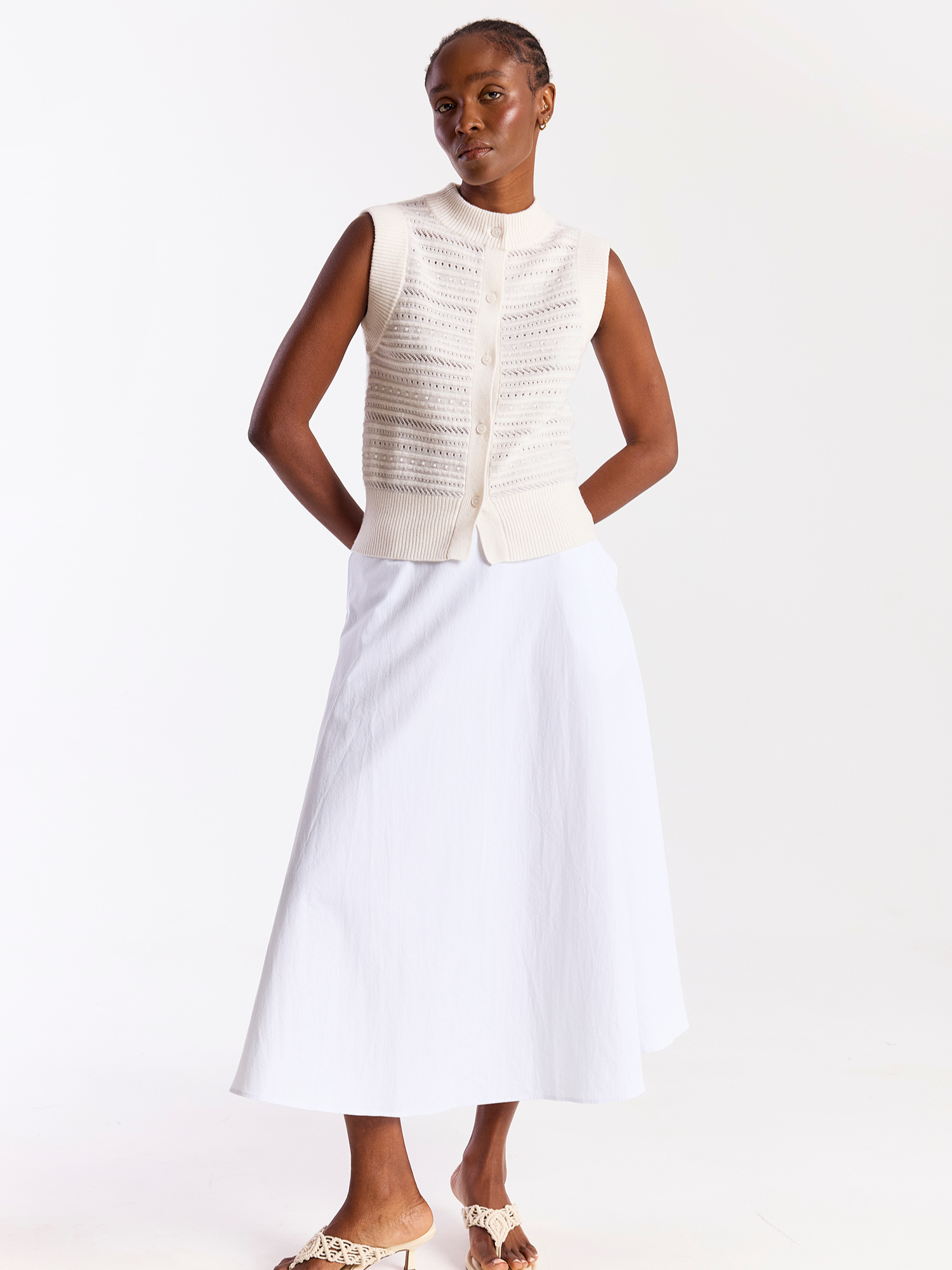 Woman wearing a white sleeveless top and skirt set on a white background