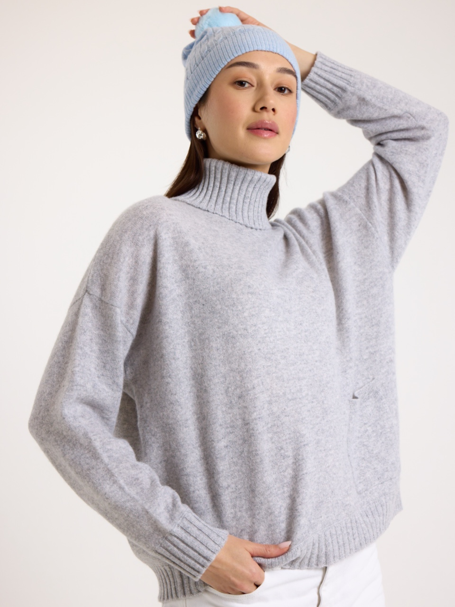 Lady wearing a blue cable cashmere pom hat