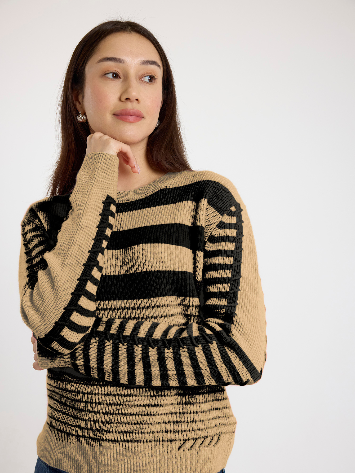 Woman wearing a beige and black striped sweater on a white background