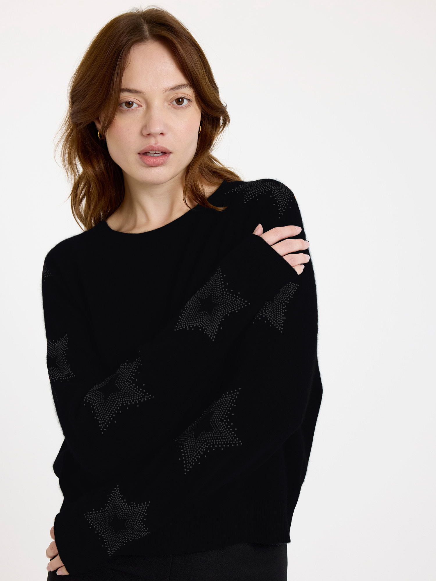 Women wearing a black sweater with subtle star design on the sleeves