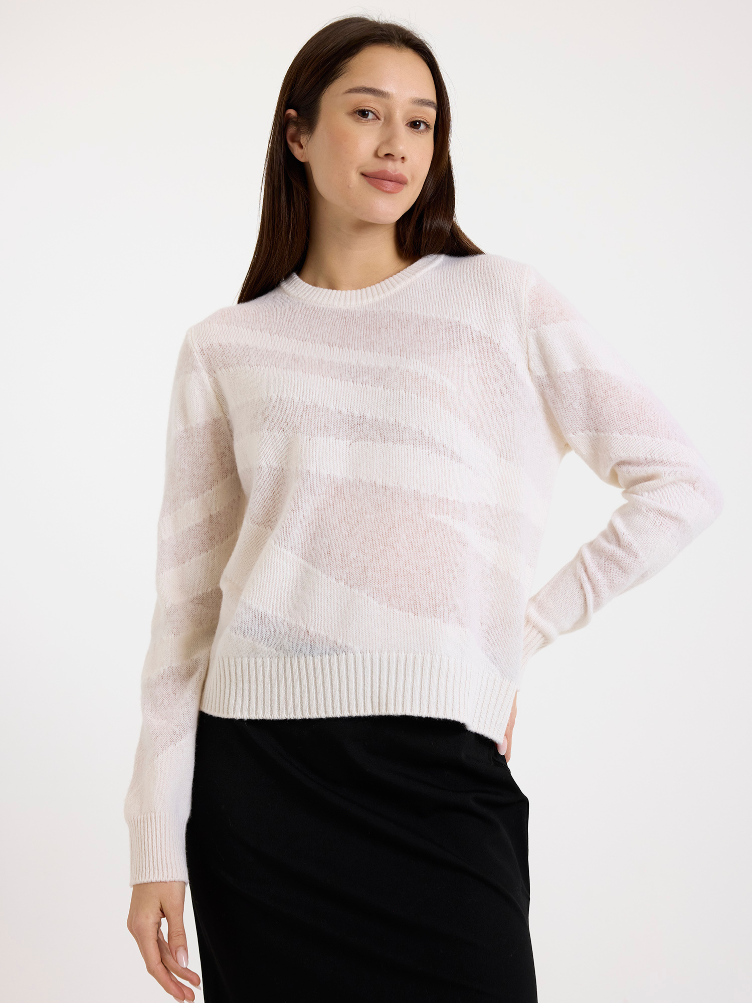 Woman wearing a white zebra detail sweater and black skirt against a white background