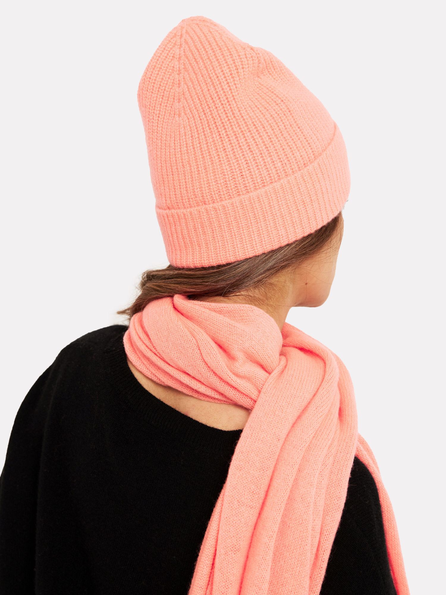 woman wearing a neon coral hat and matching scarf