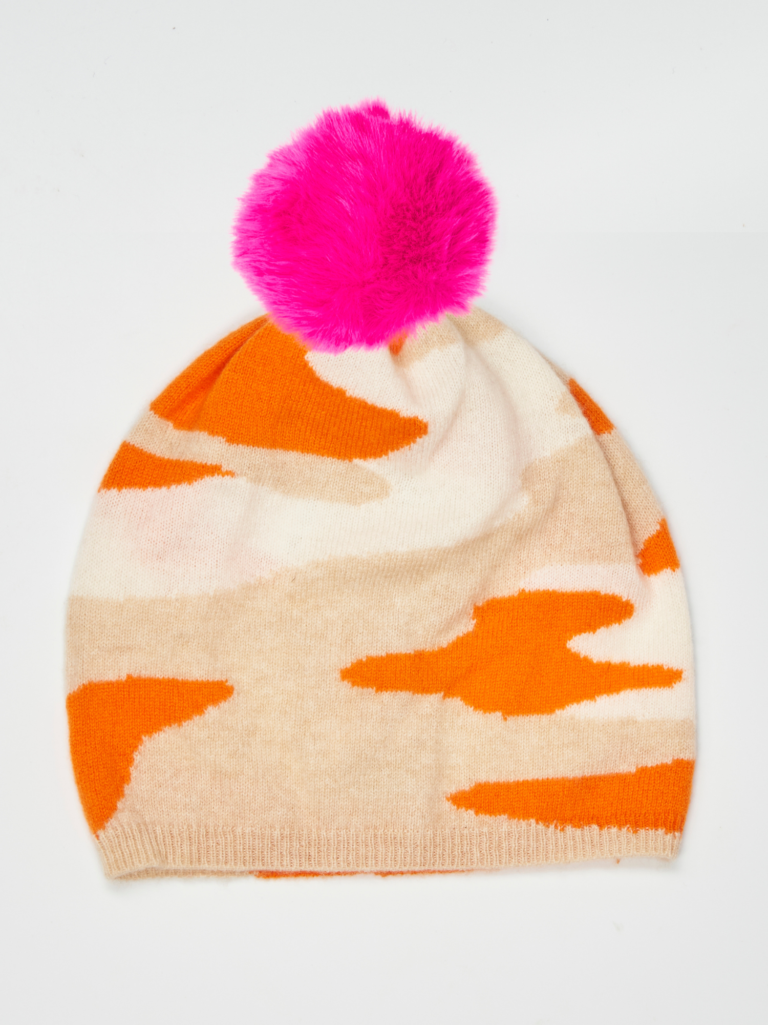Flat lay of a camo pattern hat in orange, white and beige with a pink pom pom